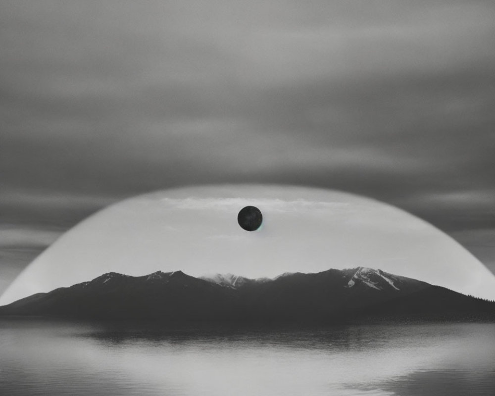 Monochrome image of serene lake, mountains, and suspended dark sphere