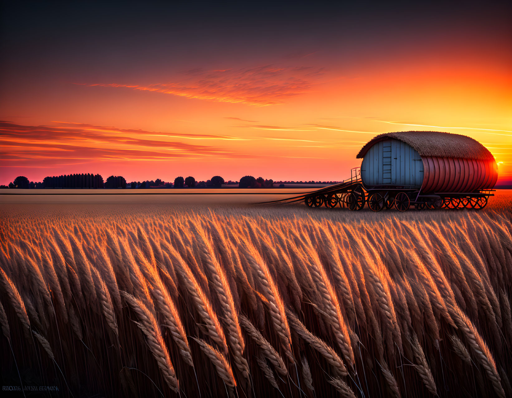 Tranquil sunset over golden wheat field with hay wagon