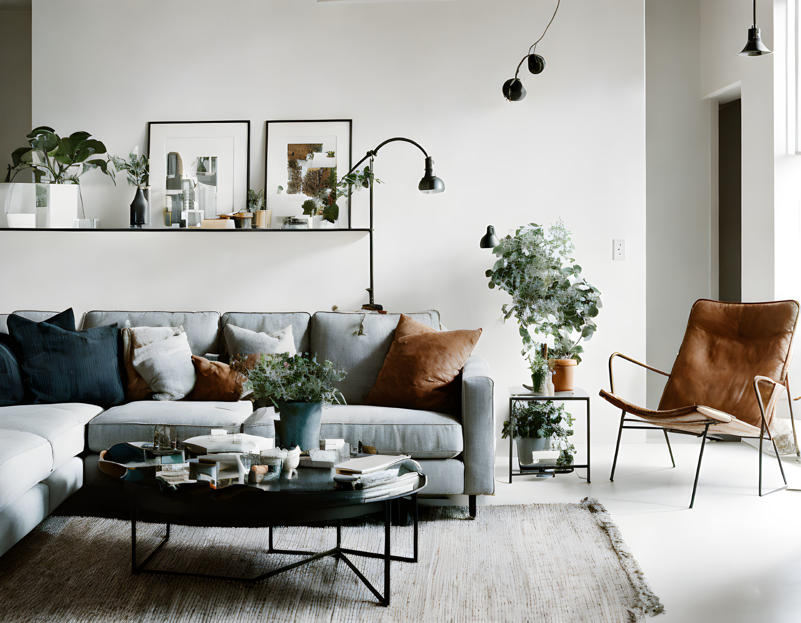 Modern Living Room with Blue Sofa, Leather Armchair, Glass Coffee Table, and Plants