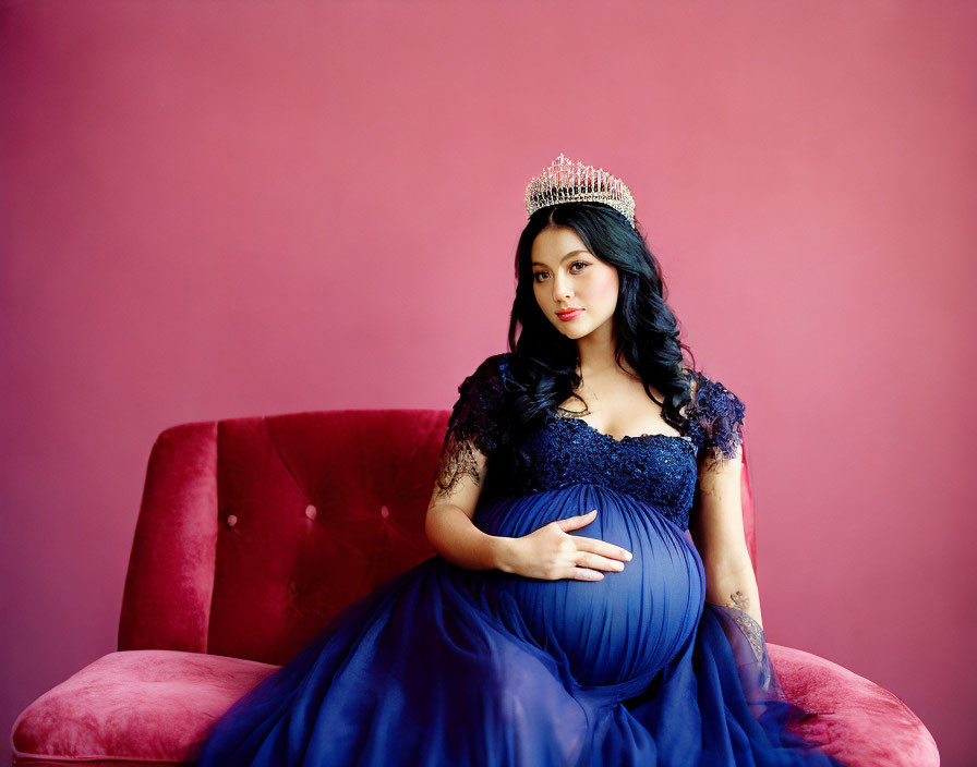 Pregnant Woman in Tiara and Blue Gown on Red Velvet Couch