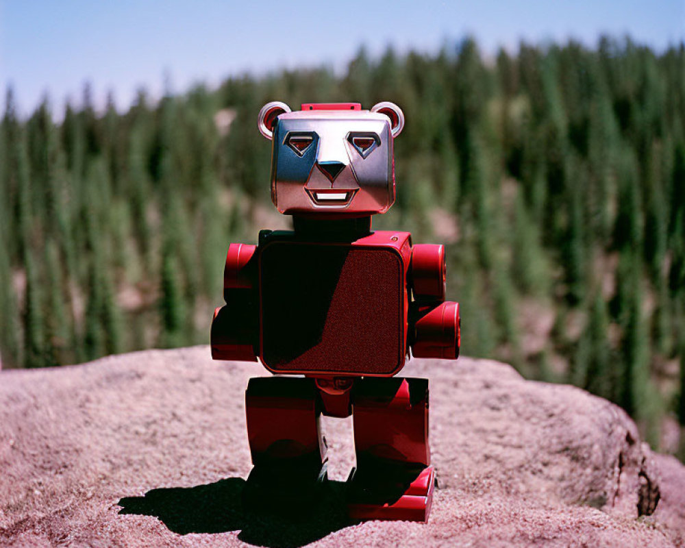 Red and Silver Bear-Shaped Robot Toy on Rock in Forest Scene