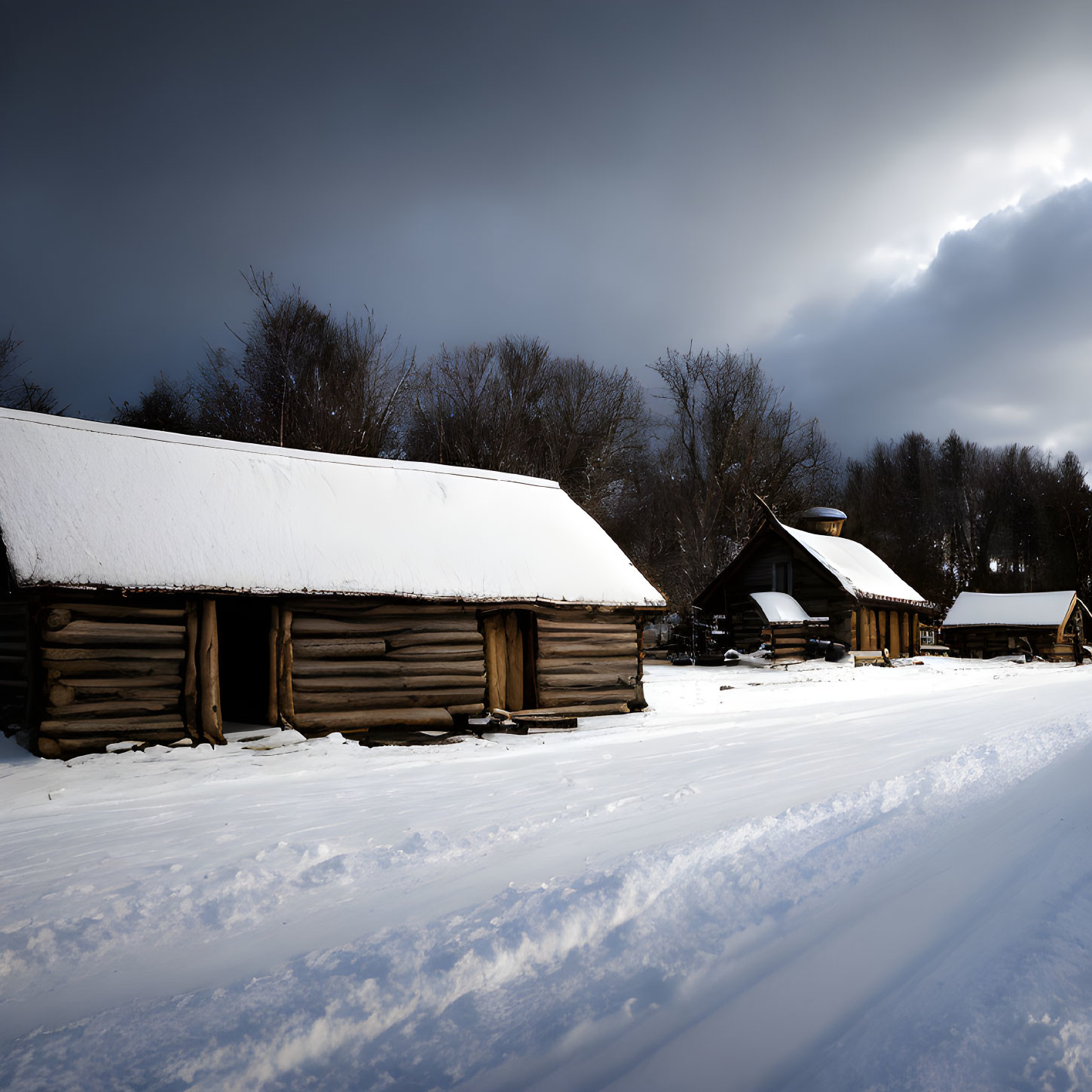 Traditional log cabins in snow under dramatic sky with sunlight breaking through clouds