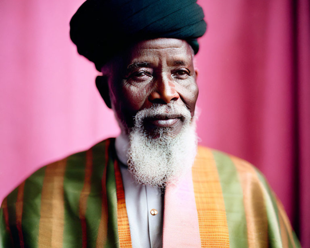 Elderly Man in Traditional Attire on Pink Background