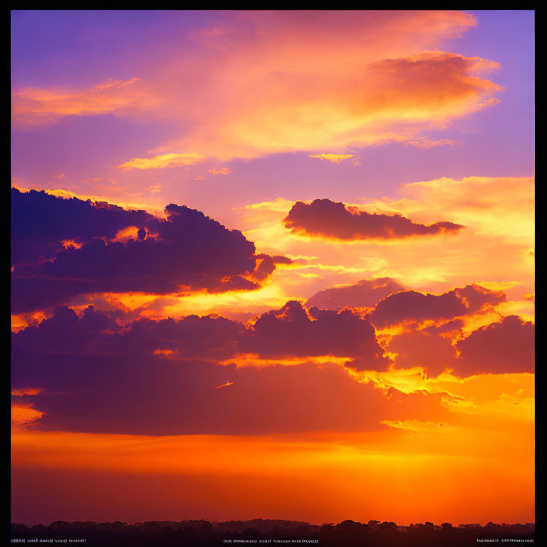 Dramatic sunset with deep oranges and yellows over dark landscape