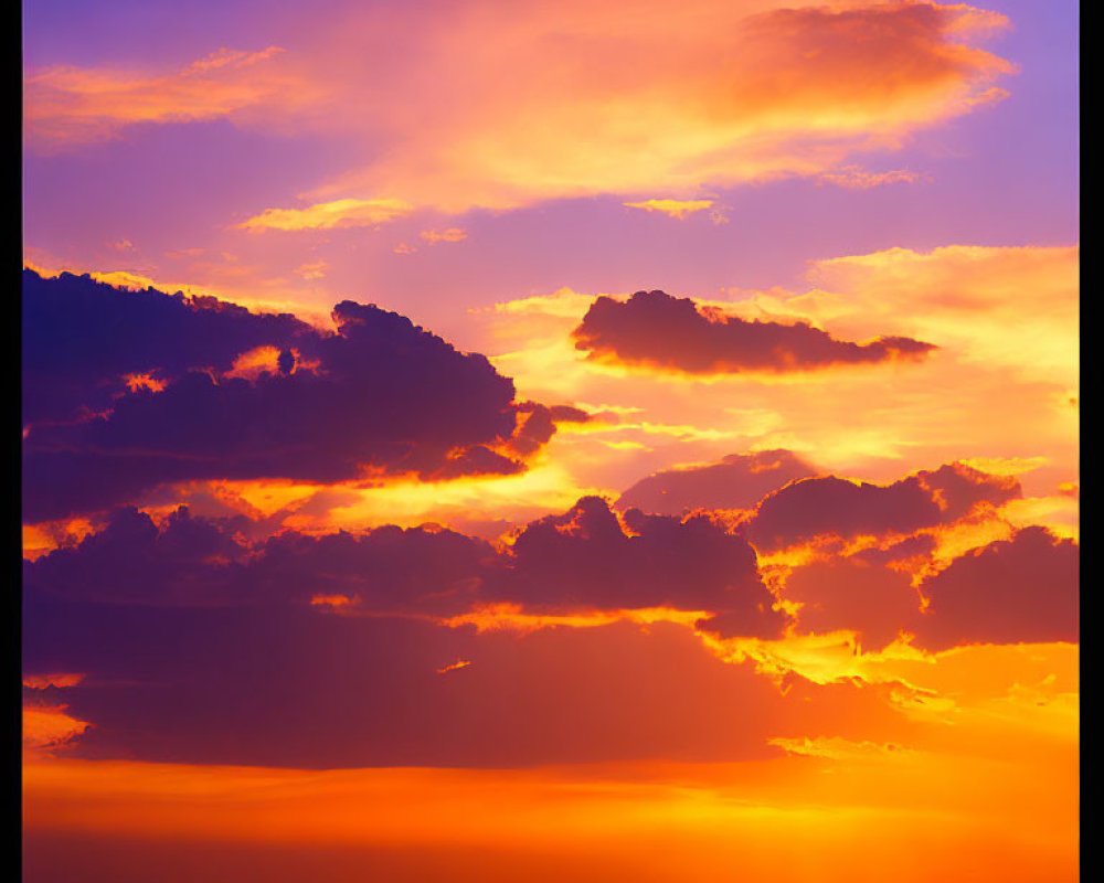 Dramatic sunset with deep oranges and yellows over dark landscape