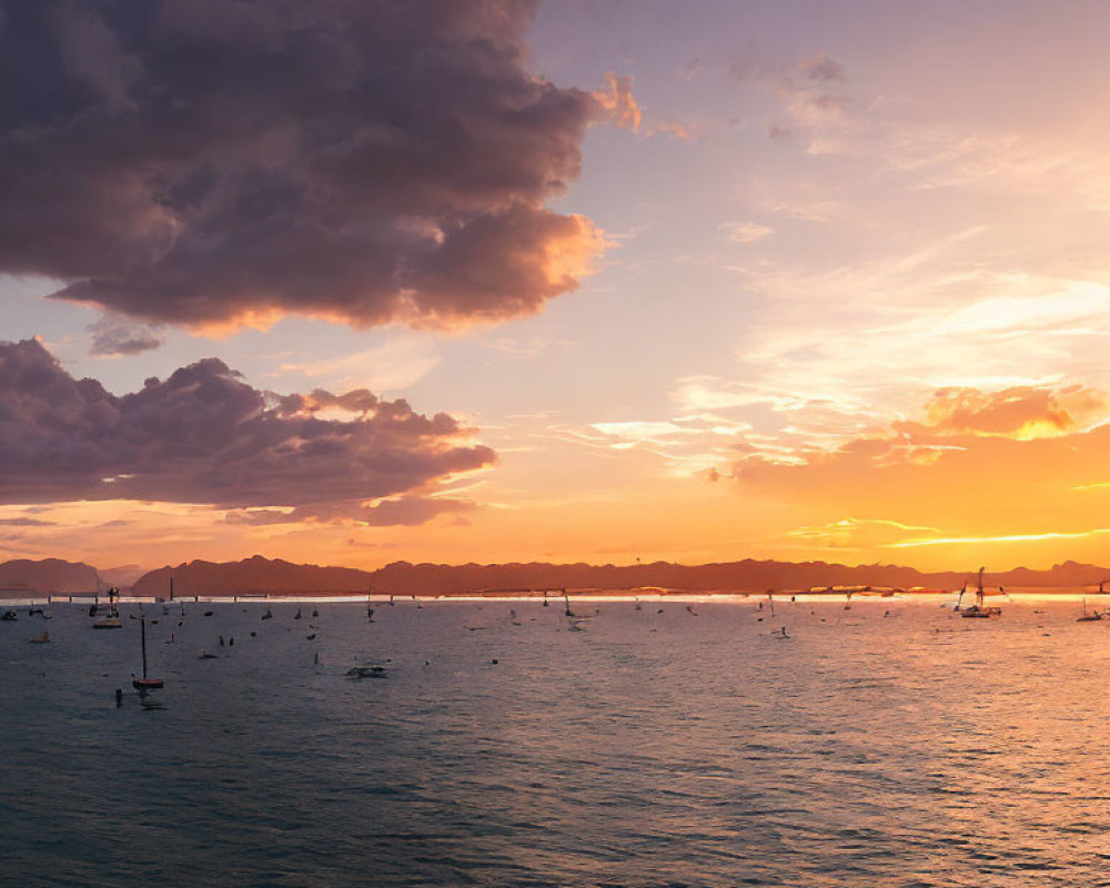 Tranquil sunset scene with boats, mountains, and orange sky