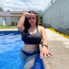 Woman in Black Swimsuit Relaxing by Sunny Poolside