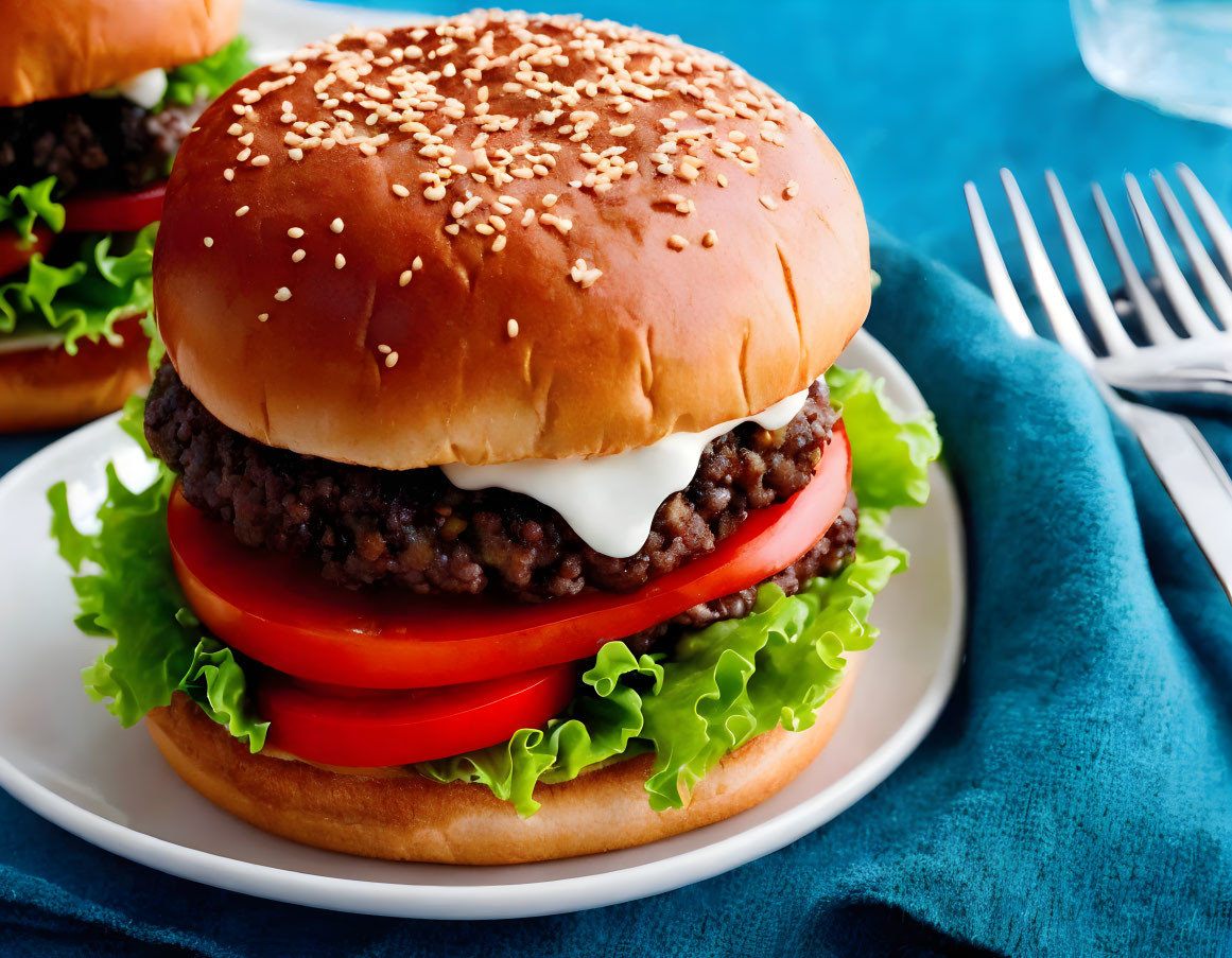 Succulent beef burger with lettuce, tomato, and creamy sauce on sesame seed bun