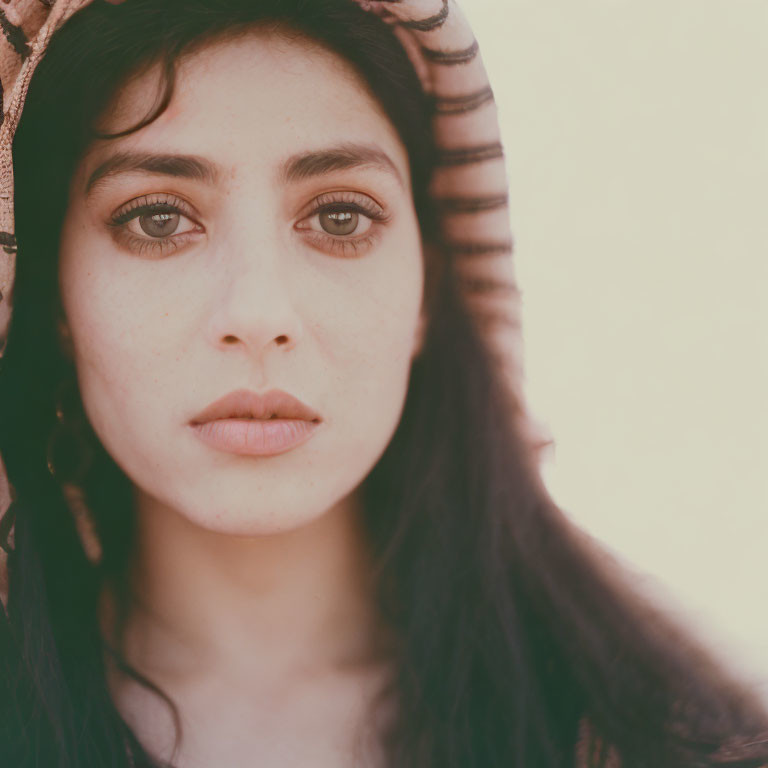 Close-Up Portrait of Woman with Dark Eyes and Hair in Striped Headscarf