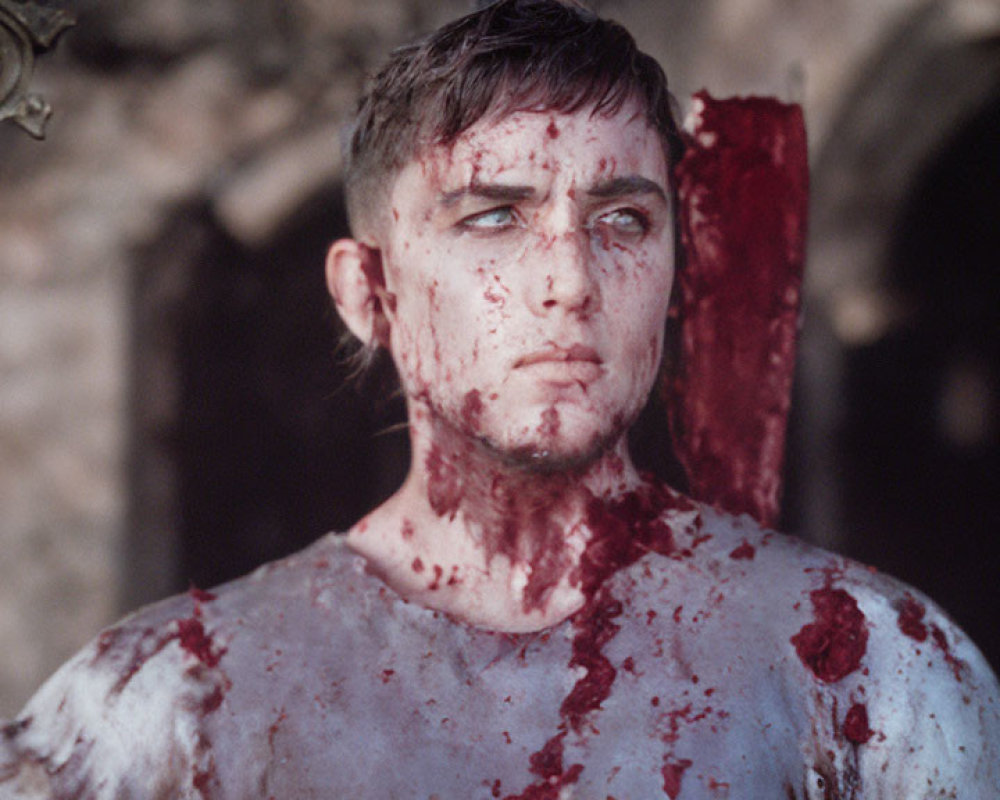 Man with blood-splattered sword in somber expression