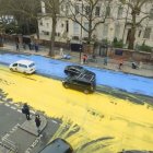 Desolate outdoor pool with cracked yellow ice, buildings, and trees on overcast day