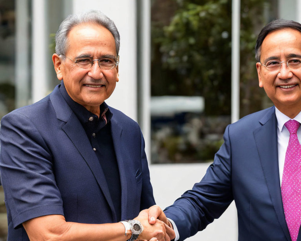 Businessmen shaking hands outdoors with blurred background