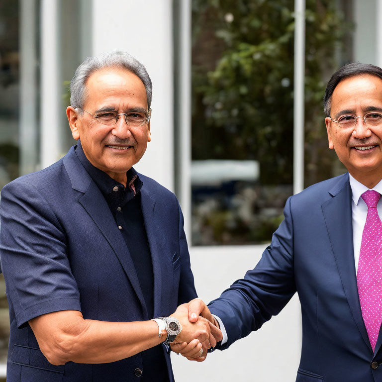 Businessmen shaking hands outdoors with blurred background