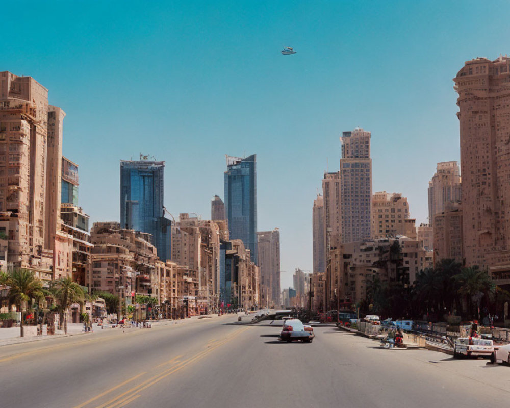 Urban street with tall buildings under construction and helicopter in blue sky