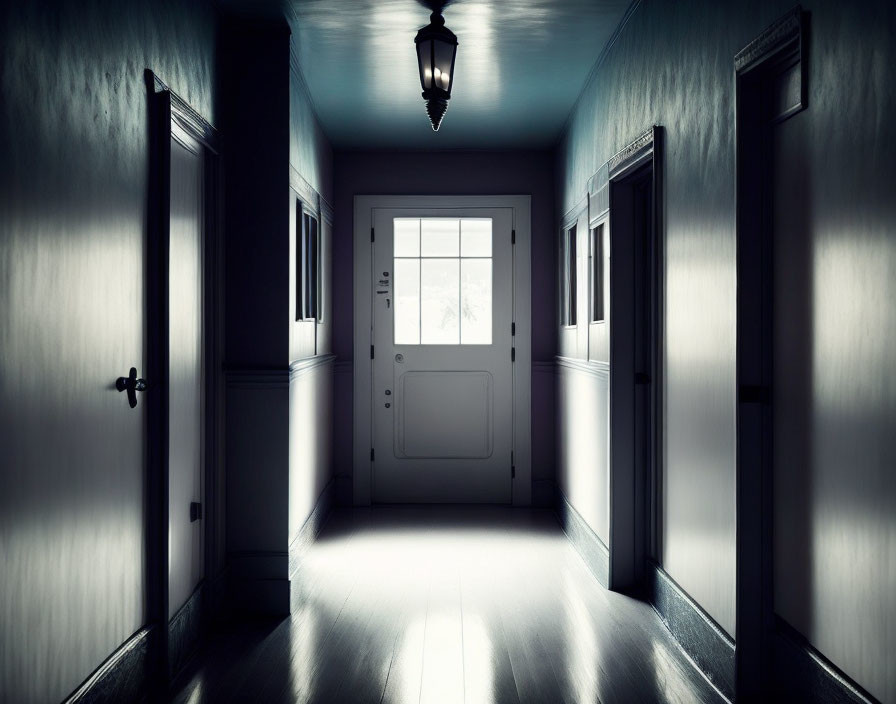 Dimly lit hallway with light through glass door, casting shadows