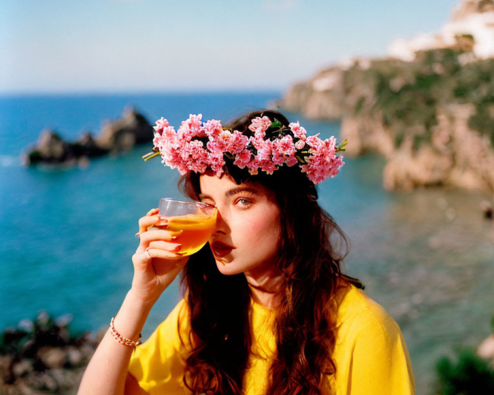 Woman in Yellow Top Sipping Beverage by Seaside Cliffs