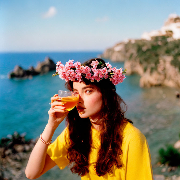 Woman in Yellow Top Sipping Beverage by Seaside Cliffs