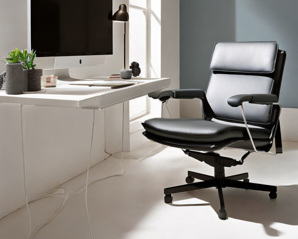 Contemporary office space with iMac, black chair, plant, and lamp by window.