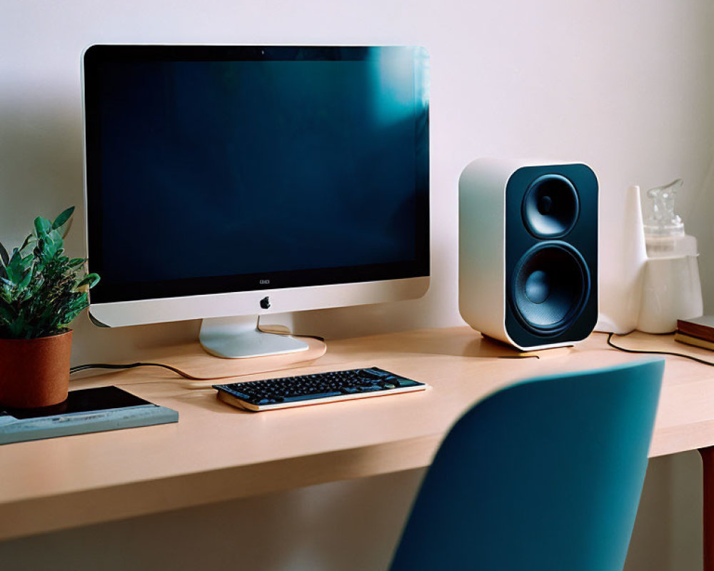 Minimalist Home Office Setup with iMac, Keyboard, Speaker, Plant, and Chair