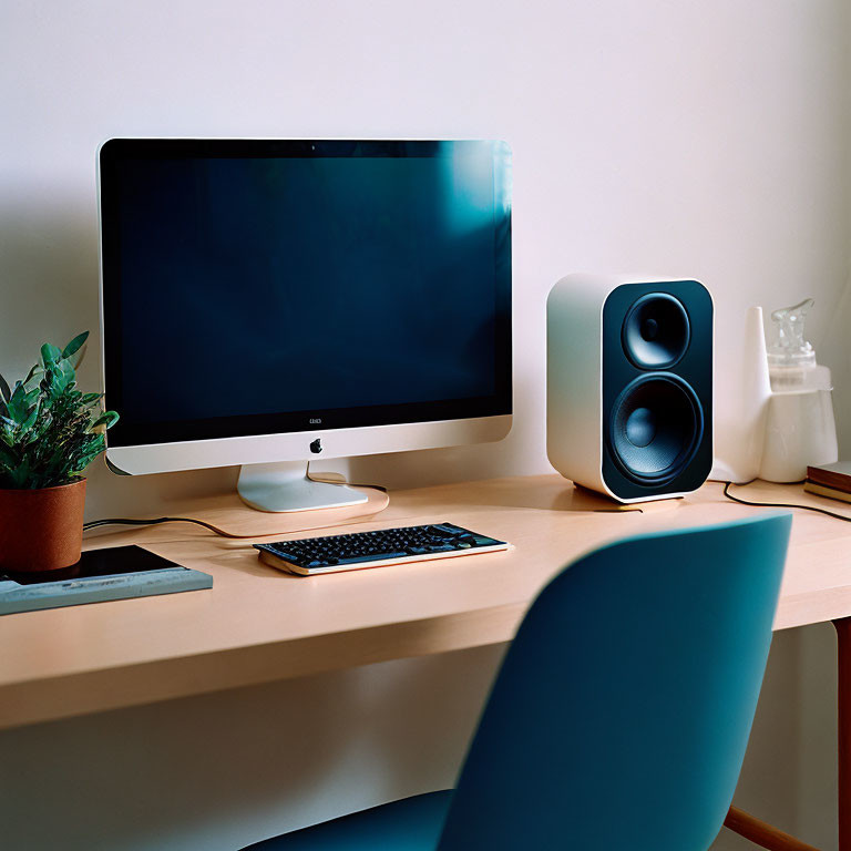 Minimalist Home Office Setup with iMac, Keyboard, Speaker, Plant, and Chair