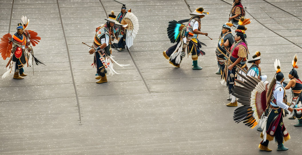 Native Americans in feather headdresses parade on pavement