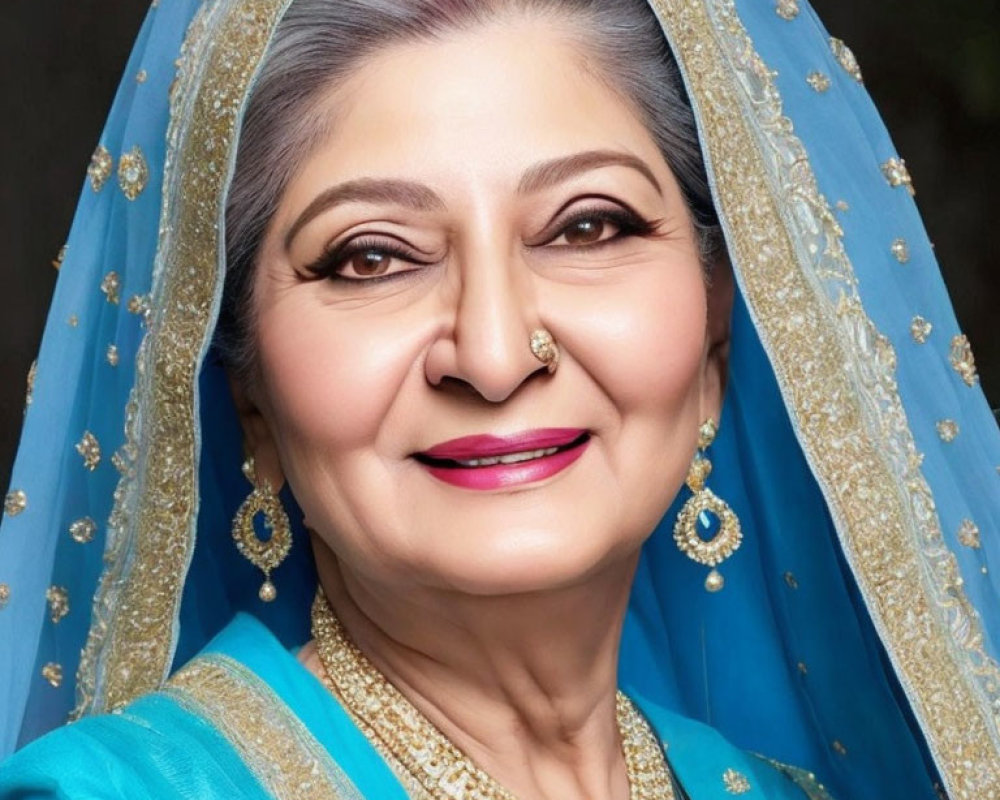 Elderly woman in blue traditional outfit with gold jewelry smiling