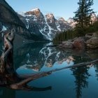 Luxury yacht with multiple decks anchored on mountain lake at dusk