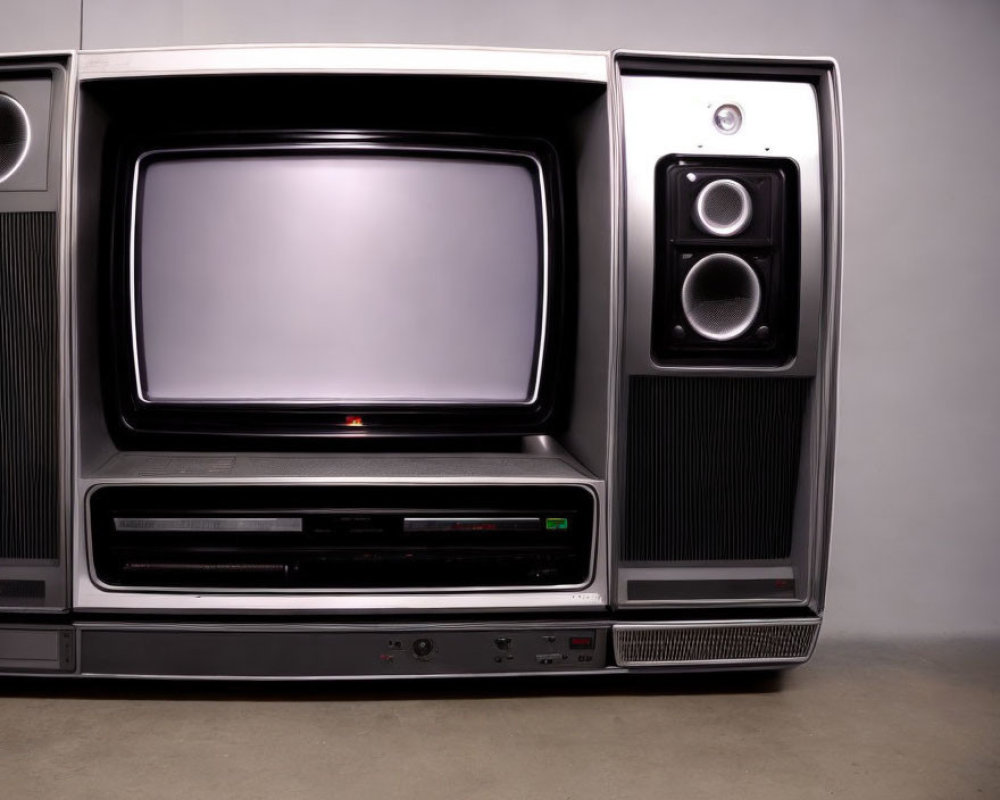 Vintage TV with large screen, side speakers, VCR, and front panel buttons on plain background