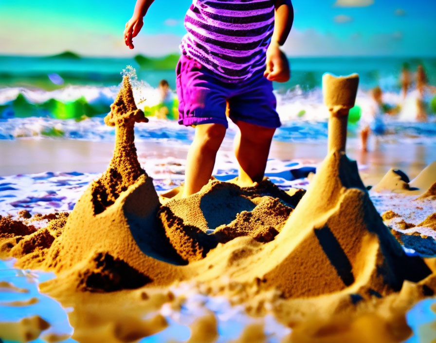 Toddler near sandcastle on sunny beach with waves and flying sand