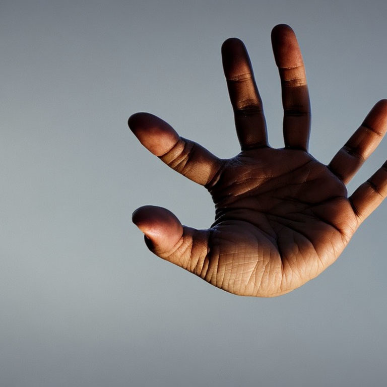 Spread out human hand against plain background