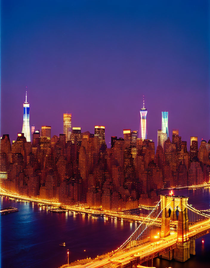 Night cityscape with illuminated bridge and skyscrapers against blue sky