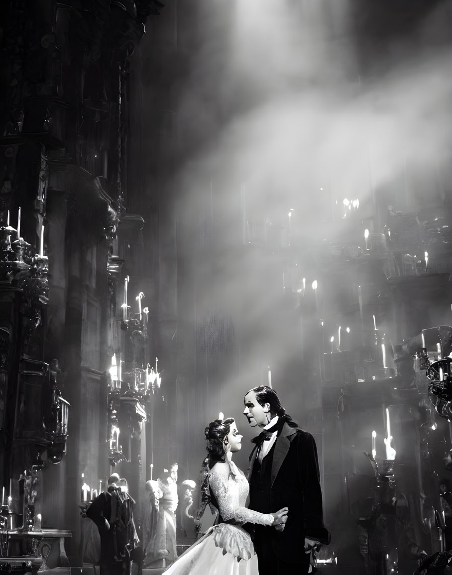 Monochrome image: Couple in historical attire dancing by candelabras