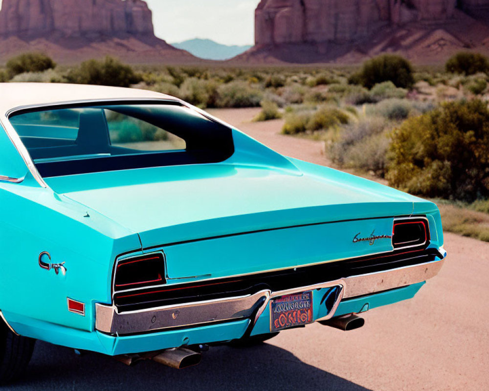 Vintage turquoise car on desert road with rocky formations and clear sky