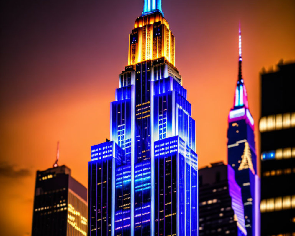 Iconic Empire State Building in blue and orange lights at dusk