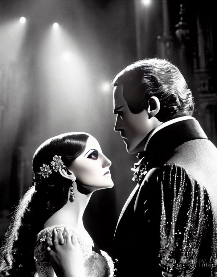 Monochrome image of man and woman in vintage costumes with dramatic lighting