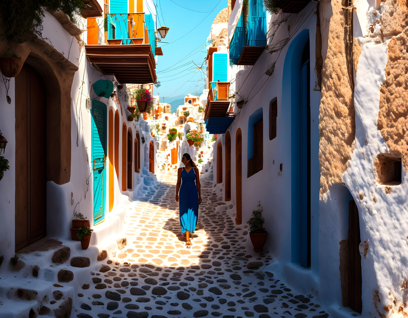 Cobblestone street with white buildings, blue doors, and person in blue dress