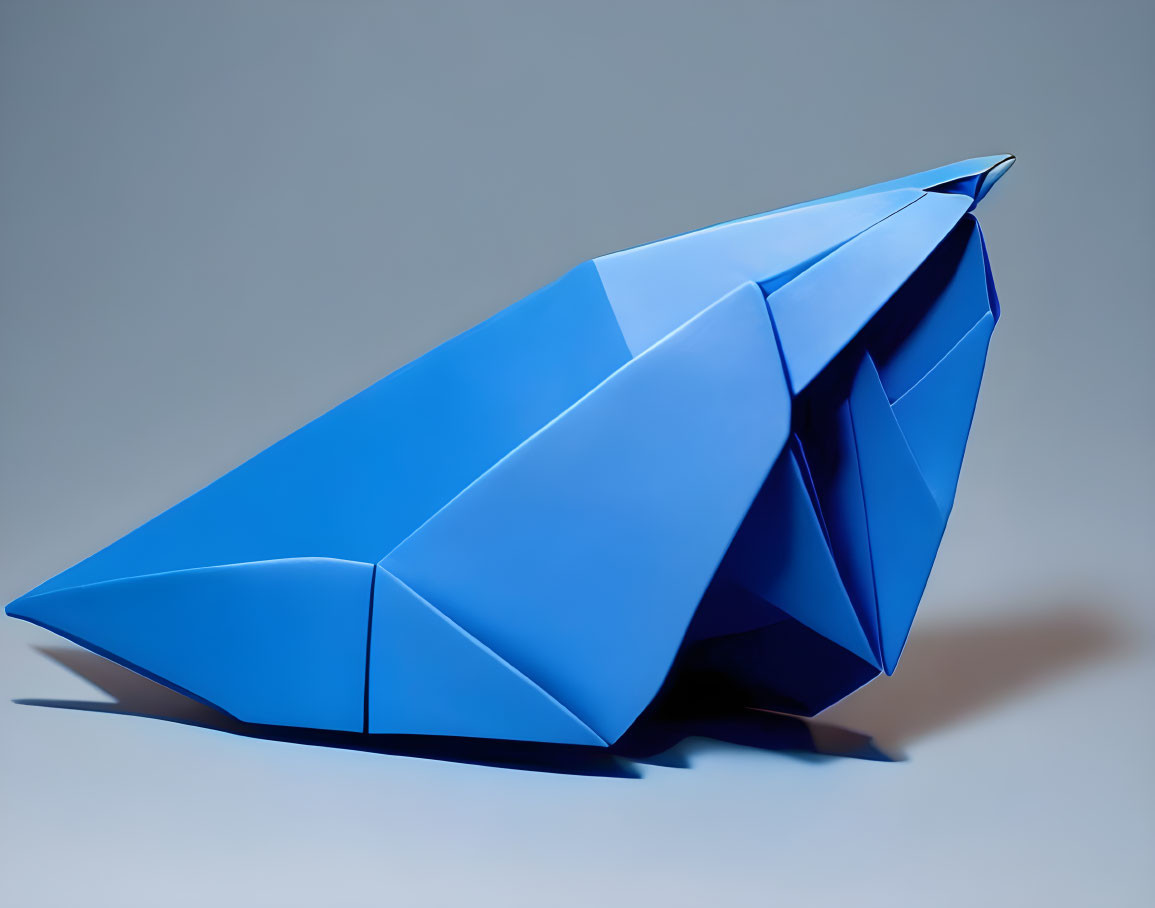 Blue Origami Whale on Grey Background with Geometric Folds