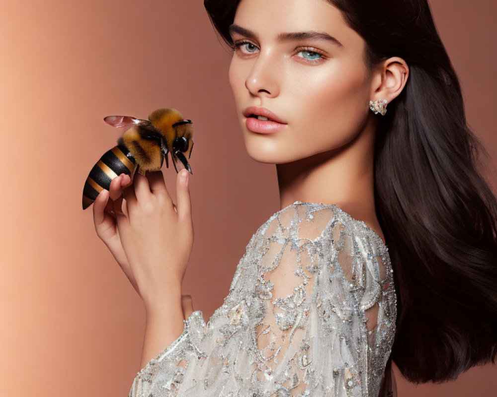 Dark-haired woman in beaded dress with bumblebee on hand