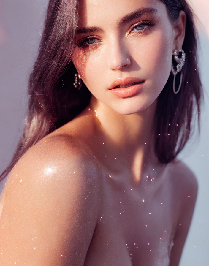 Portrait of Woman with Sparkling Skin and Intense Eyes on Pink Background