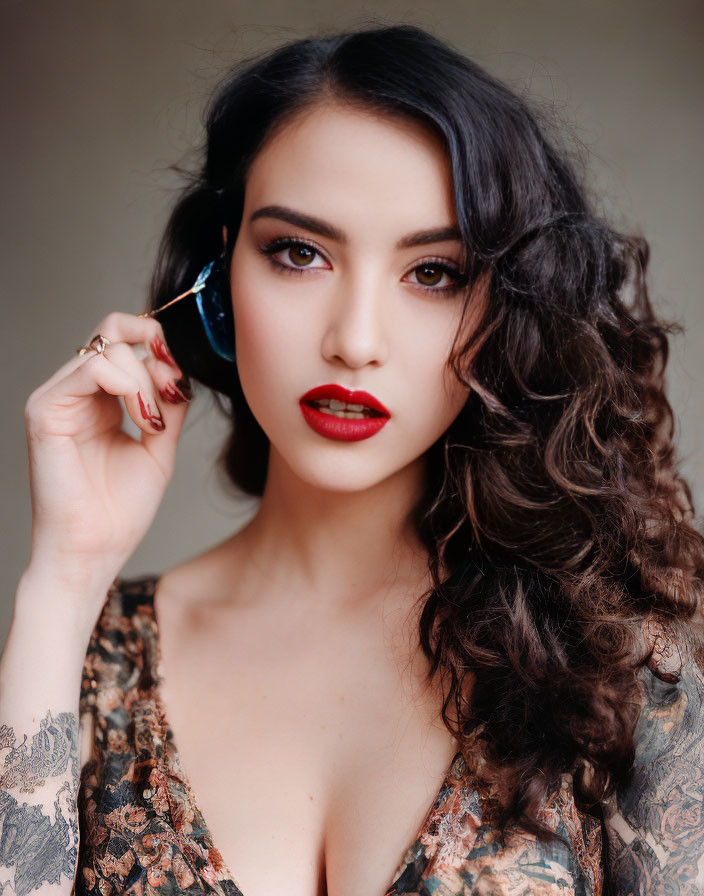 Dark Curly-Haired Woman in Floral Outfit with Red Lipstick and Sunglasses