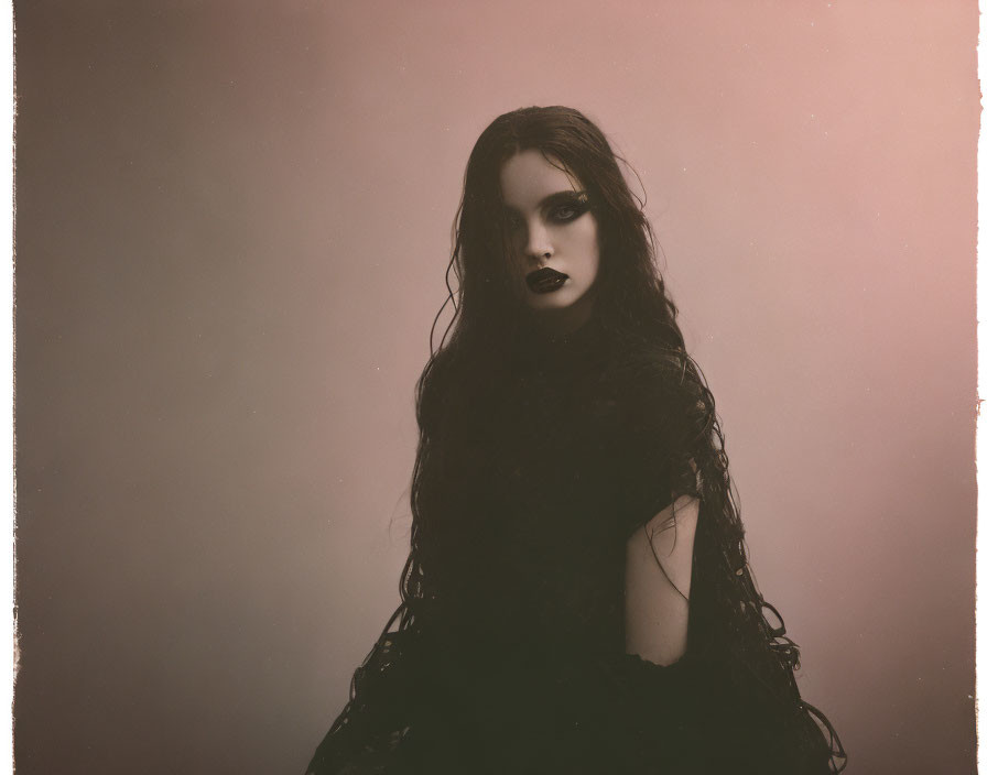 Person in Dark Makeup and Black Outfit on Soft Pink Background