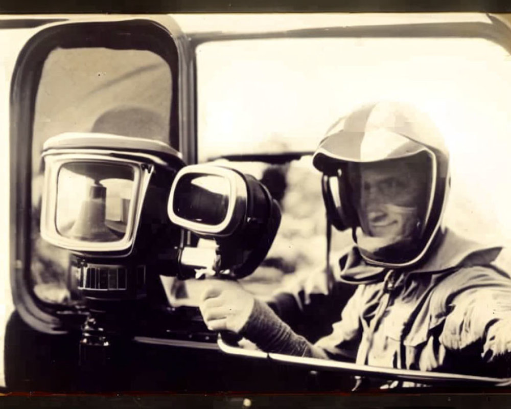 Smiling person in vintage photo with helmet pointing in race car