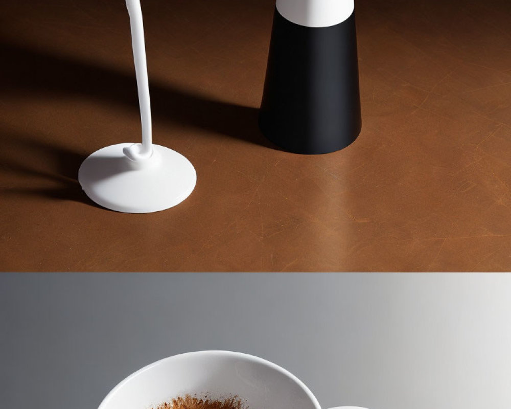 Two-tone desk lamp and white cup on brown surface.