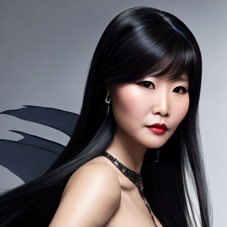 Asian woman portrait with long black hair and red lipstick on gray background