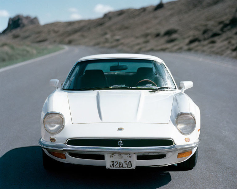 Classic Sports Car with Pop-Up Headlights on Open Road