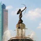 Warrior woman statue on rearing horse with spear and bird in cloudy sky