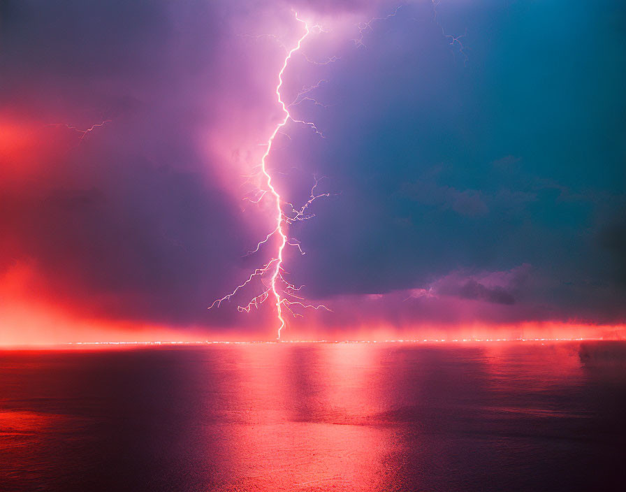 Colorful lightning storm above water with pink and blue reflections