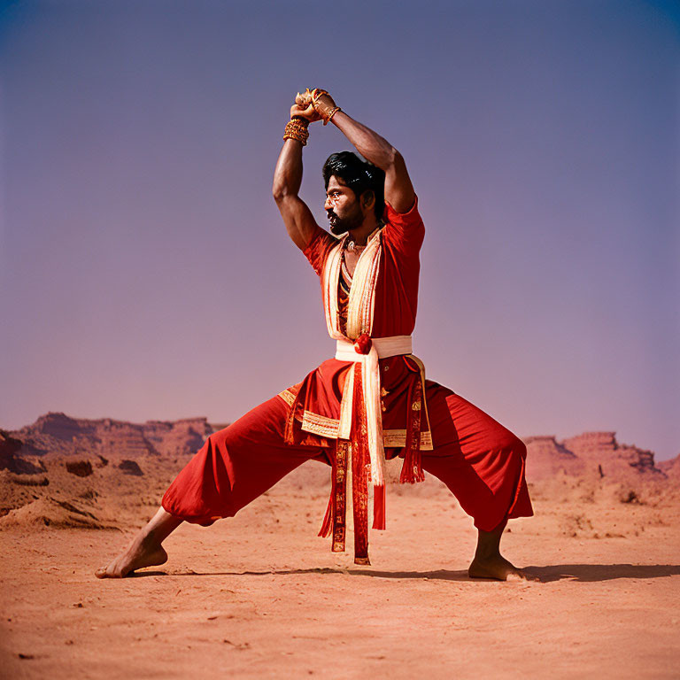 Person in Red Traditional Attire Doing Martial Arts in Desert