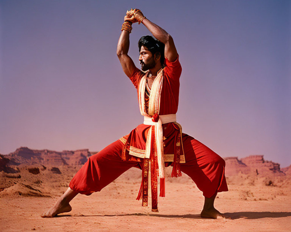 Person in Red Traditional Attire Doing Martial Arts in Desert