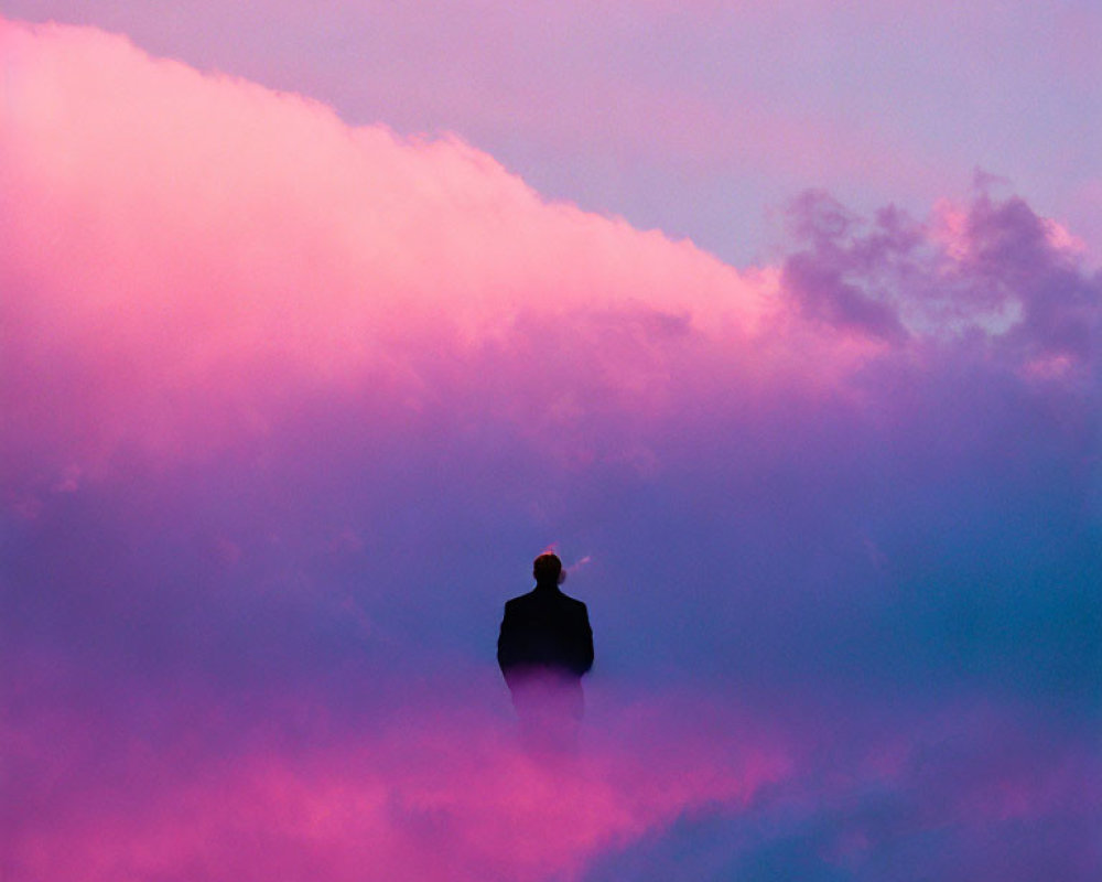 Silhouetted person against vibrant pink and purple sky